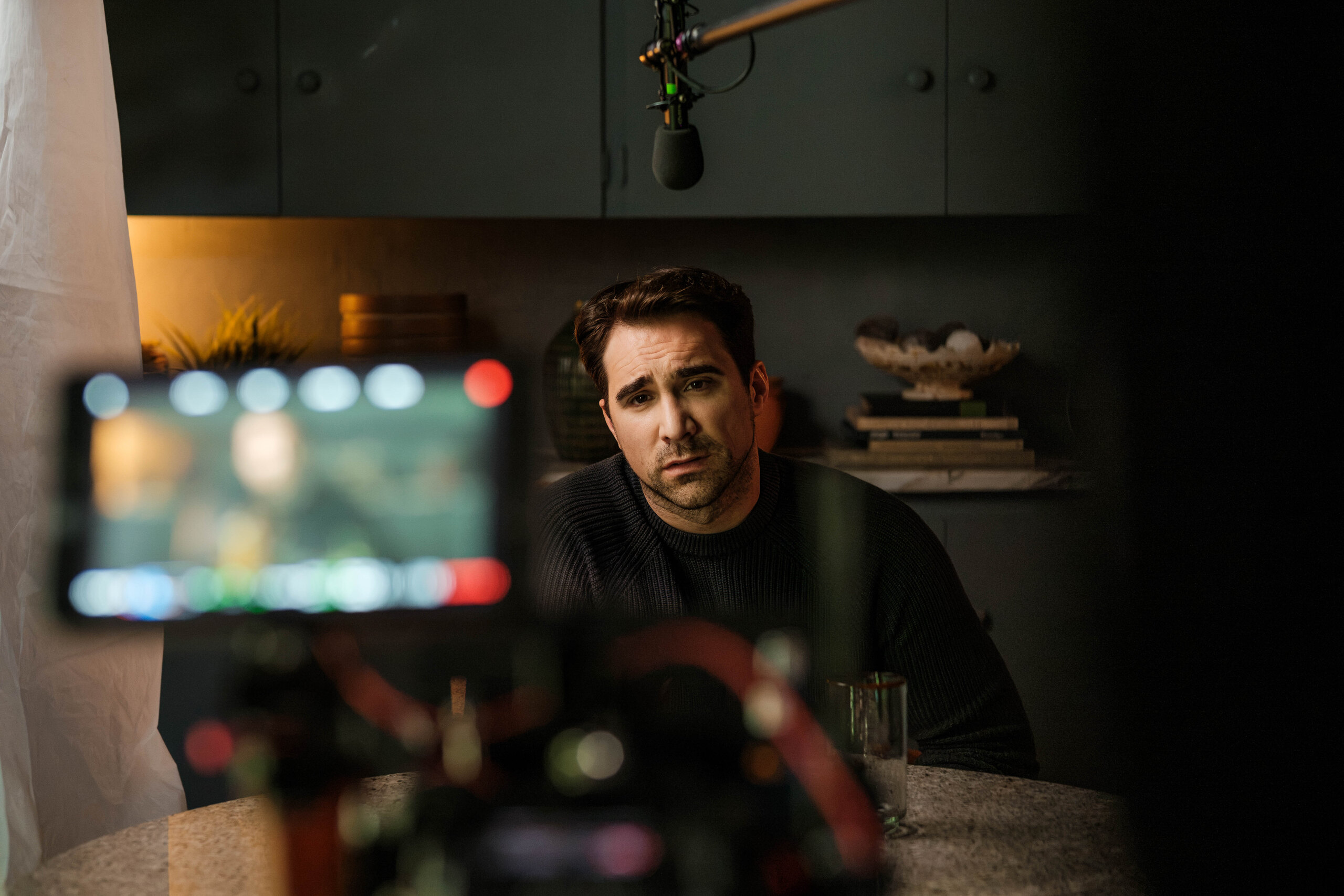 Justin Ray at the table, framed on the camera's monitor.